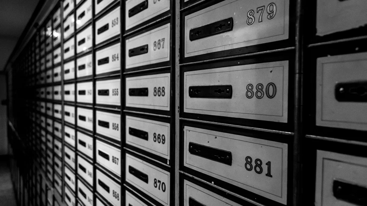 Filas de buzones metálicos numerados, en blanco y negro
