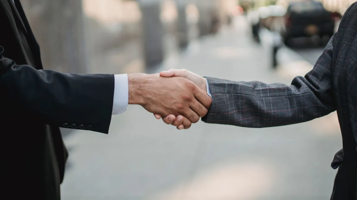 Apretón de manos entre dos profesionales cerrando un acuerdo comercial