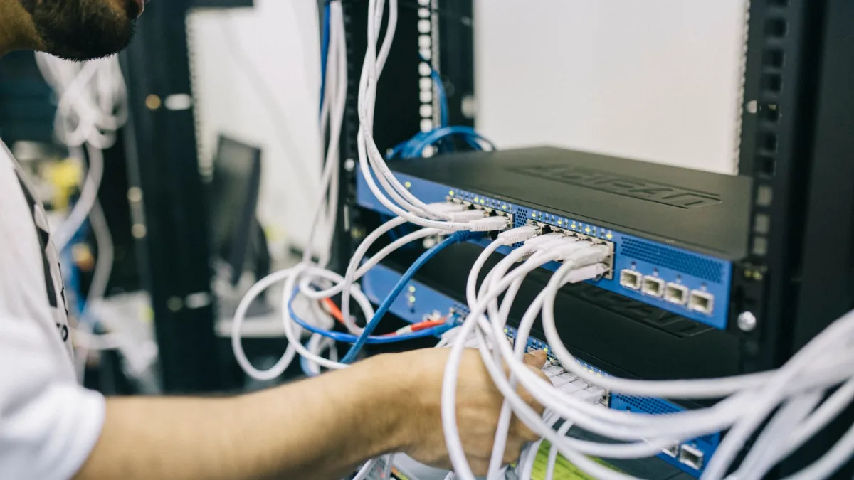 Técnico conectando cables de red en un armario de servidores