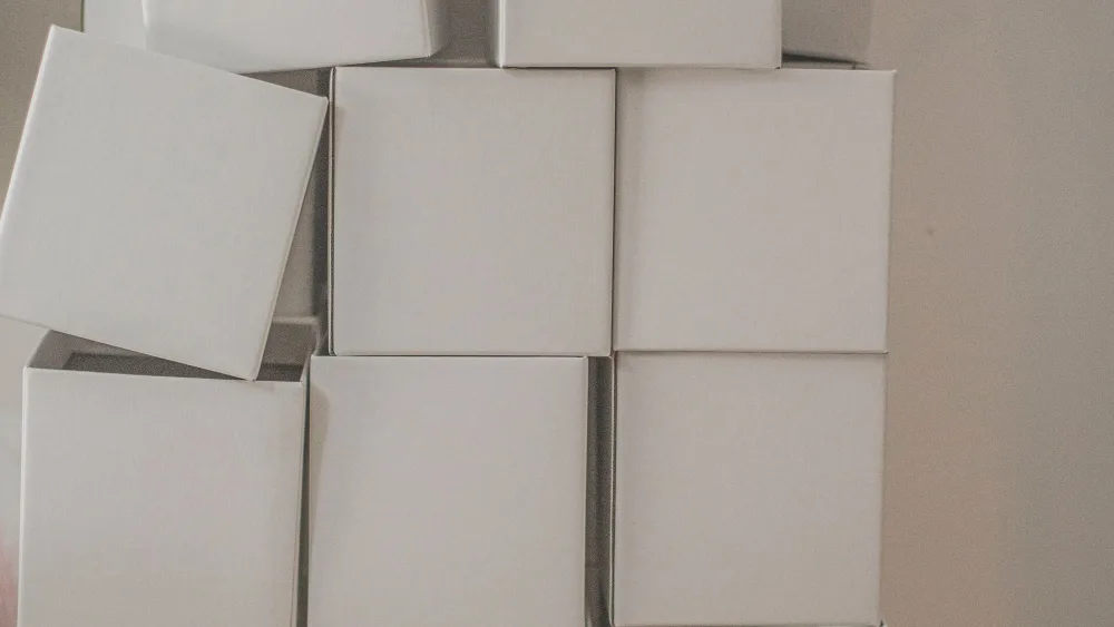 Cajas de cartón blancas idénticas y sin etiquetar, apiladas unas sobre otras