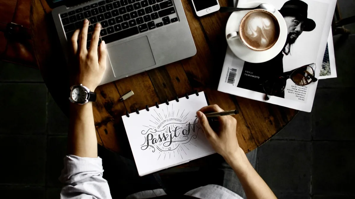 Escritorio de diseño web con un portátil y material de bocetado sobre la mesa