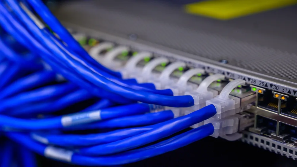Cables de red azules conectados a un conmutador en un armario de comunicaciones