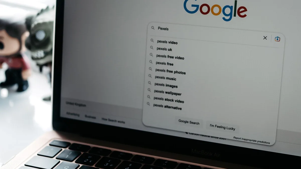 Un portátil abierto mostrando la caja de búsqueda de Google con sugerencias desplegadas