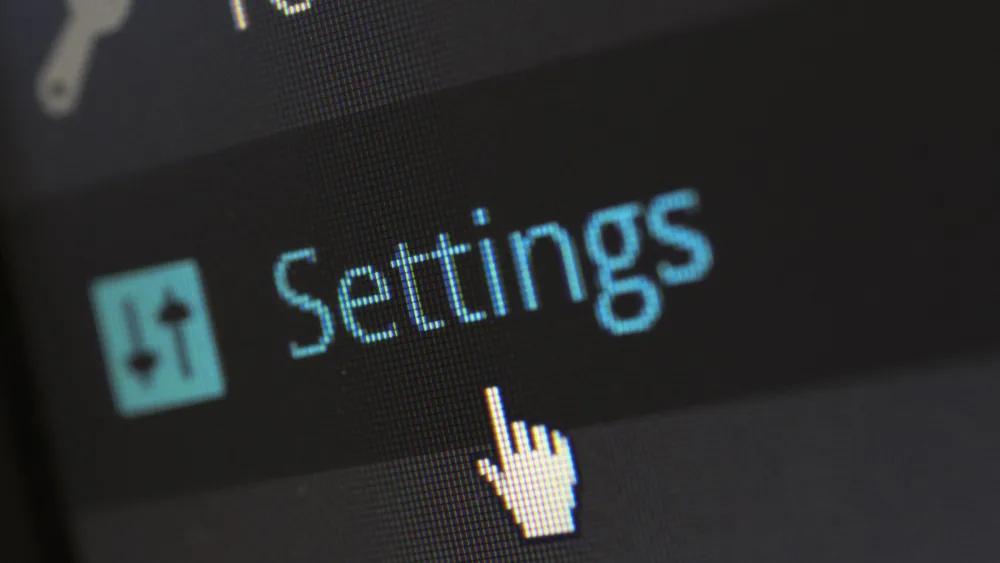 Pantalla con un menú de ajustes y un cursor de mano señalando una opción
