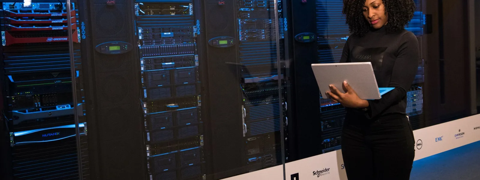 Una ingeniera de sistemas trabaja junto a los racks de un centro de datos